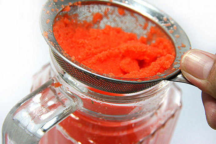 Dùng lưới lọc để loại bỏ bã cà rốt 