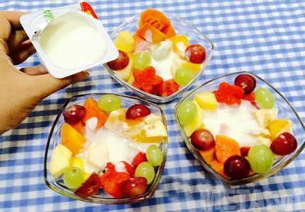 Cho hoa quả và sữa chua vào cốc hoặc bát rồi trộn đều