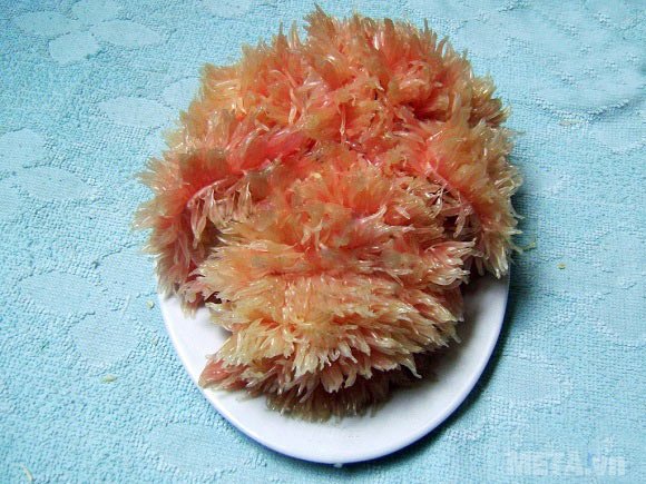 Dùng 2 múi bưởi dài nhất ghim vào phần đầu làm tai của chú chó Dùng 2 múi bưởi dài nhất ghim vào phần đầu làm tai của chú chó