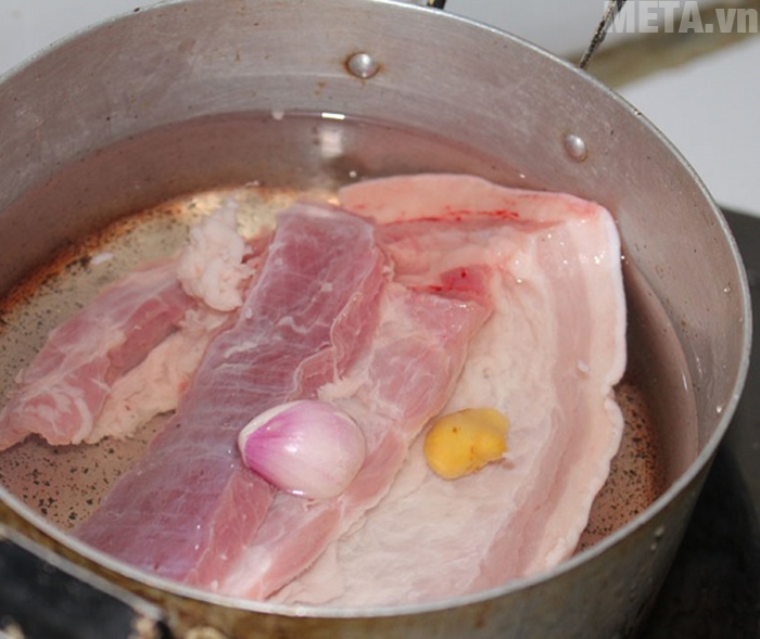 Bạn luộc thịt với hành và gừng để tăng vị thơm cho món ăn