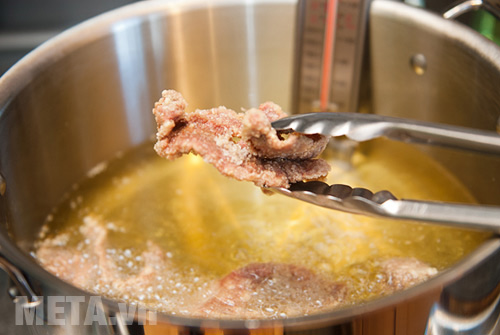 Chiên thịt bò trong chảo dầu