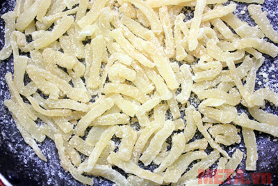 Khi củ cải sôi bạn giảm lửa và đảo đều tay cho đường ngấm vào củ cải