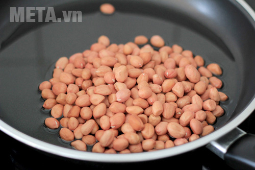 Cho lạc vào chảo rang chín Cho lạc vào chảo rang chín