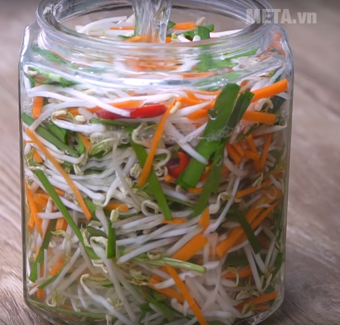  Đổ hỗn hợp nước vừa pha vào hũ đựng dưa giá