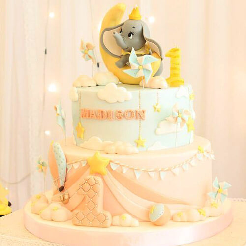 Bánh kem 2 tầng cho bé gái được trang trí bằng những chú voi ngộ nghĩnh và tông màu cam vàng rực rỡ
