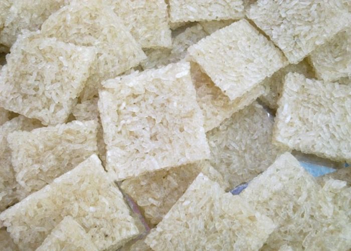 Cắt cơm đã ép mỏng thành từng miếng nhỏ vừa ăn