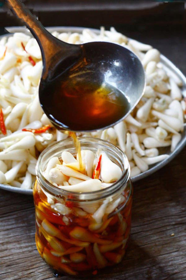 Đổ nước mắm đường vào lọ dưa kiệu