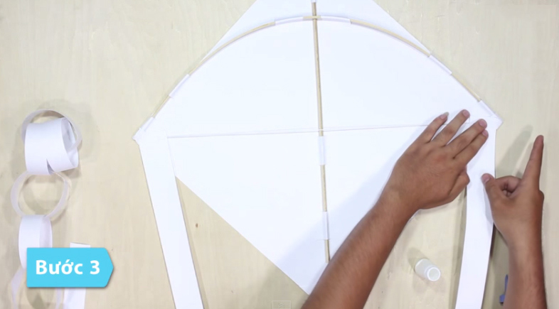 Dùng các rải ruy băng dán sang 2 góc đối xứng nhau qua thanh tre ở giữa