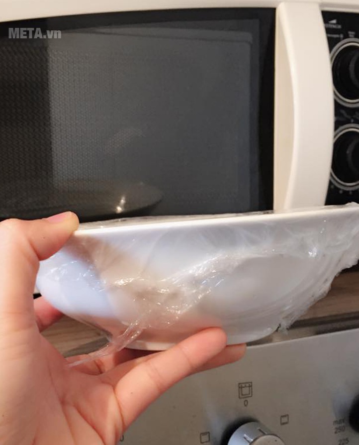 Quay cơm nguội trong lò vi sóng để hâm nóng cơm