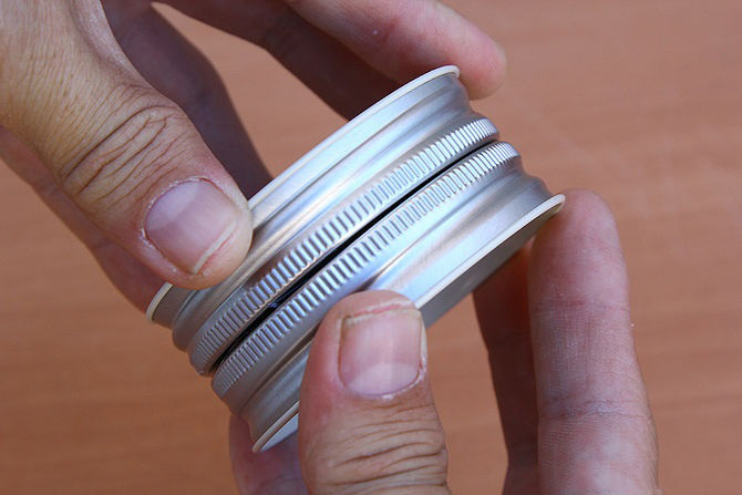 Gắn 2 nắp lọ lại với nhau, giữ chặt tay đến khi keo khô