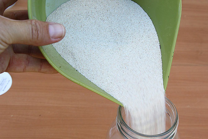 Đổ cát vào bên trong lọ thủy tinh