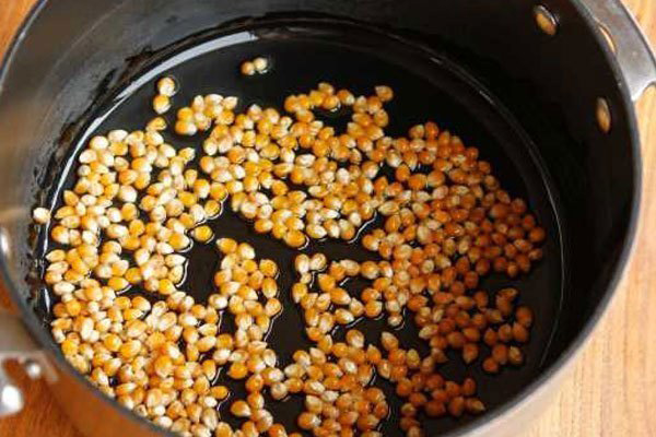 Cho hạt bắp Mỹ vào, dùng đũa đảo đều, đậy nắp lại rồi điều chỉnh nhiệt độ nồi chiên không dầu khoảng 180oC trong 10 phút