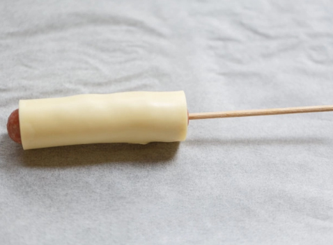 Dùng miếng phô mai cuộn đều bên ngoài xúc xích