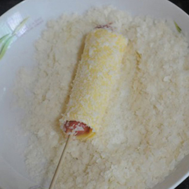 Lăn đều thanh xúc xích vào đĩa dừa nạo