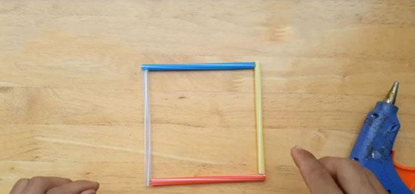 Xếp bốn đoạn ống hút khác màu tạo thành hình vuông rồi dùng súng bắn keo gắn chúng lại với nhau
