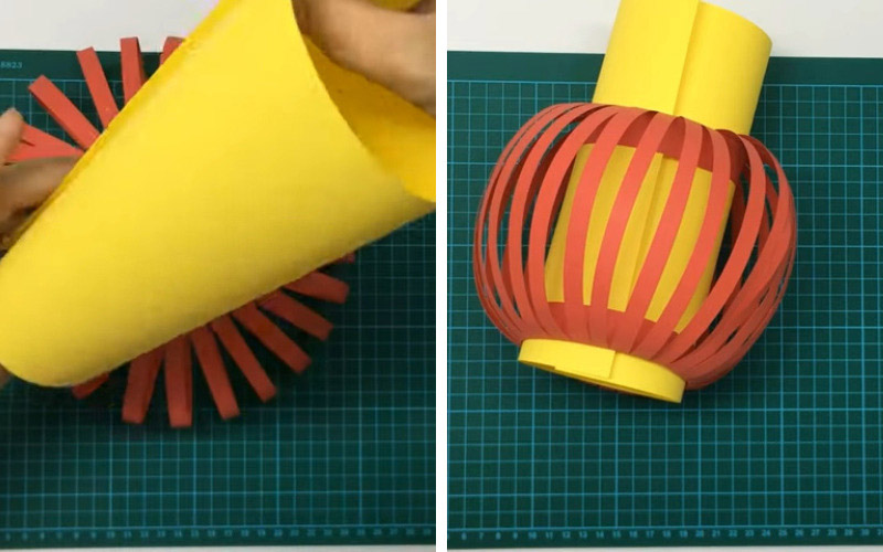 Tờ giấy còn lại, bạn đem uốn cong rồi dùng băng dính cố định lại để tạo thành ống trụ dài, đặt vào giữa lồng đèn để làm ruột của lồng đèn