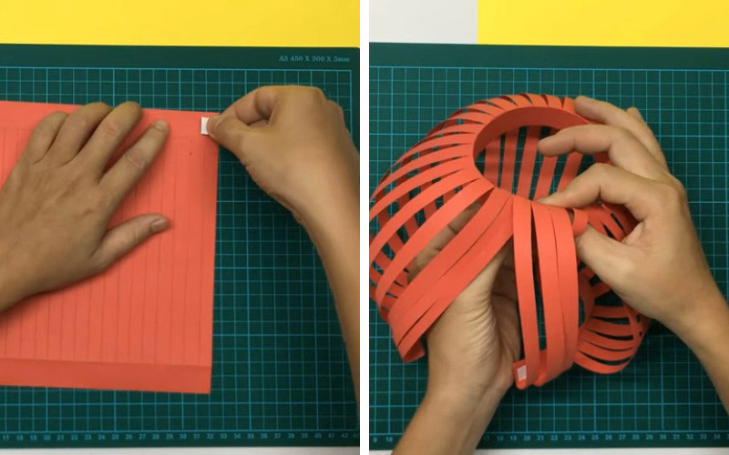 Dùng băng dính hai mặt dán vào hai đầu của tờ giấy vừa cắt, uốn cong nhẹ nhàng để chúng tạo thành vòng tròn rồi cố định lại