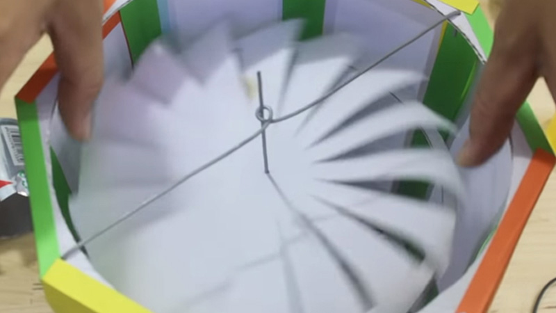 Lấy một thanh sắt quấn thành (như hình) rồi đục 2 lỗ ở 2 bên mép của nắp lồng đèn, sau đó gắn thanh sắt vào là xong