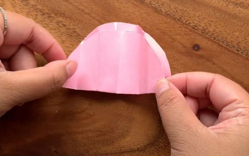 Bạn gấp hai mặt giấy lại với nhau, đội giấy khô thì bạn đổ keo lên mặt ngoài của miếng giấy theo vị trí ngoài cùng bên trái, giữa, ngoài cùng bên phải rồi dán miếng khác đè lên