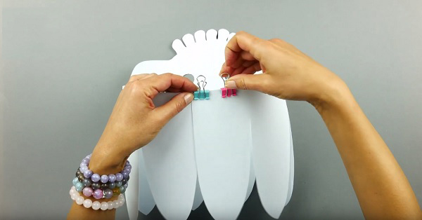 Cuộn hình dán lại rồi dùng kẹp ghim cố định chúng vào với nhau sao cho tạo thành hình tròn