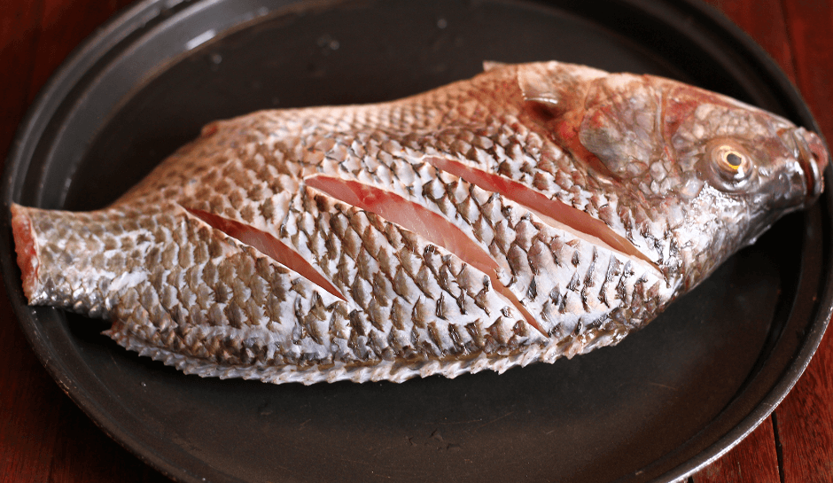 Dùng dao khứa nhẹ thân cá để tạo đường sọc chéo giúp cá dễ ngấm gia vị hơn