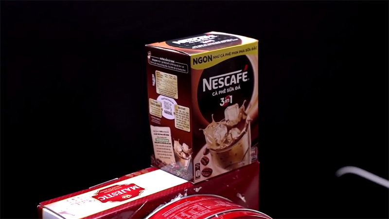 Bôi keo lên phần trên của hộp bánh rồi đặt hộp cà phê lên trên, giữ đến khi keo khô