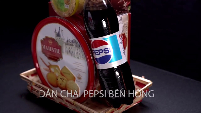Bôi keo lên hai bên của hộp bánh rồi dán mứt gừng và chai Pepsi ở hai bên là được
