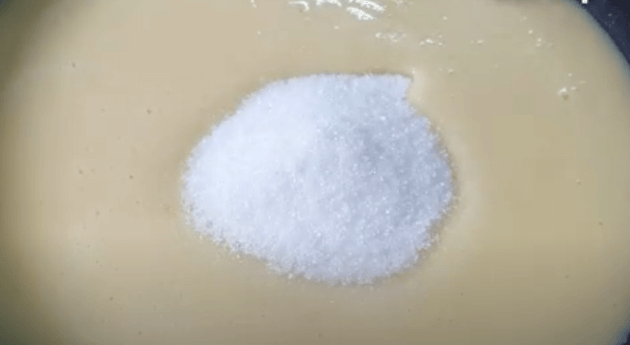 Thêm đậu xanh vừa xay và 100g đường vào chảo chống dính